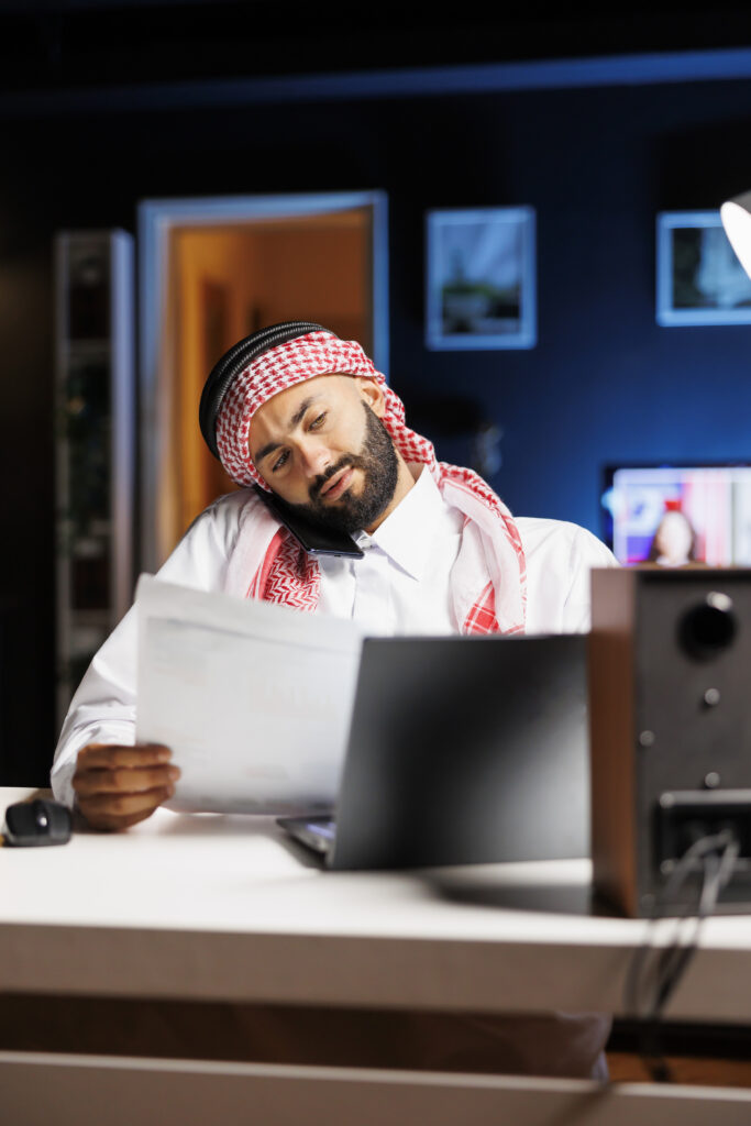 Arab man on phone at office desk